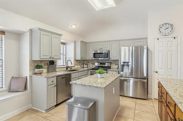 a kitchen with stainless steel appliances granite countertop a refrigerator sink and stove