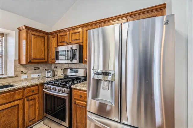 a kitchen with stainless steel appliances a refrigerator stove and sink