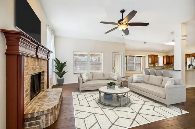 a living room with furniture a fireplace and a large window