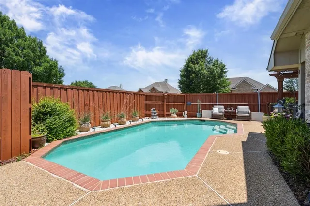a view of a swimming pool with a patio and a yard