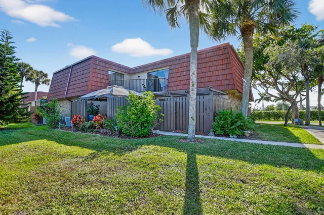 a view of a house with a yard and potted plants