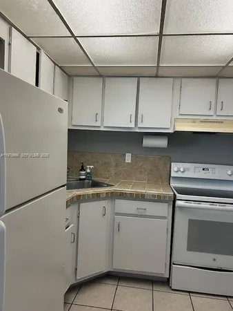 a kitchen with granite countertop cabinets stainless steel appliances and a sink