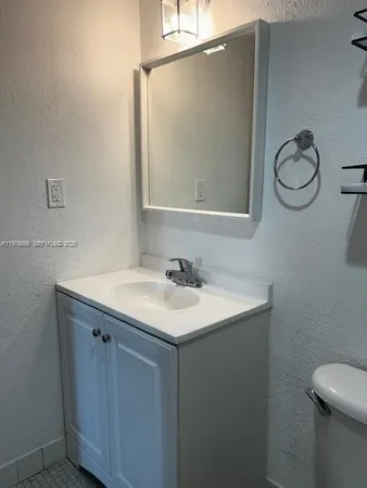 a bathroom with a sink a toilet and a mirror