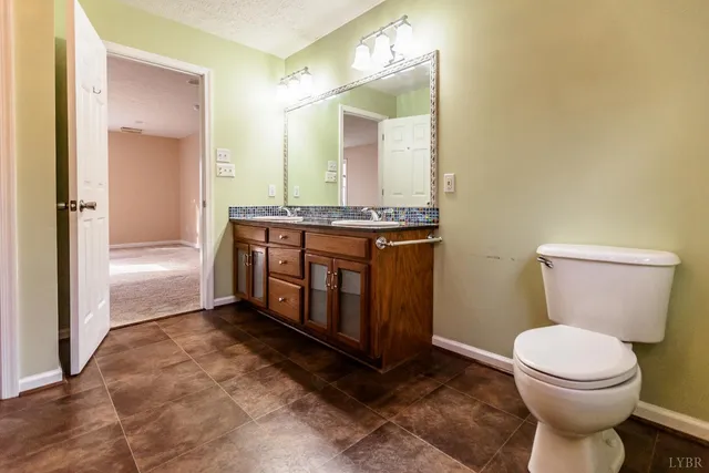 a view of an empty room with window and chandelier fan