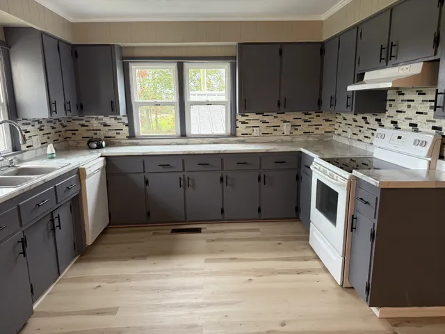 a kitchen with stainless steel appliances granite countertop a stove a sink and a microwave