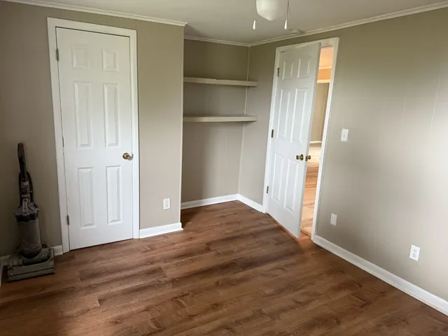 a view of empty room with wooden floor
