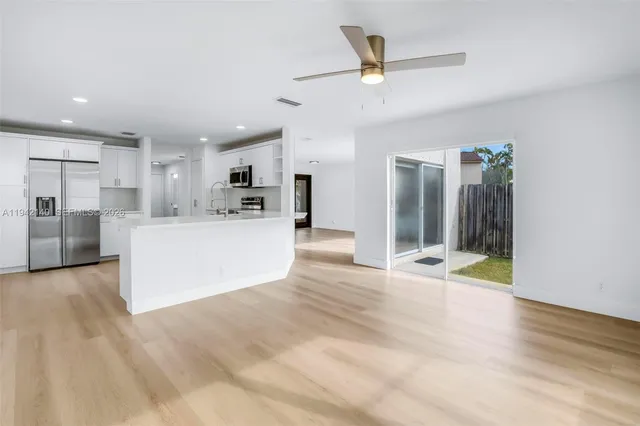 a view of a kitchen with a sink and an empty room