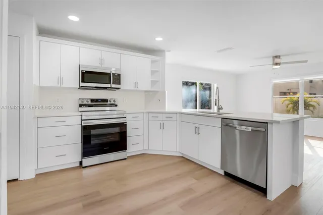 a kitchen with white cabinets and stainless steel appliances