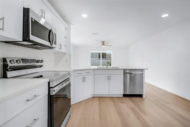 a kitchen with stainless steel appliances a stove microwave and sink