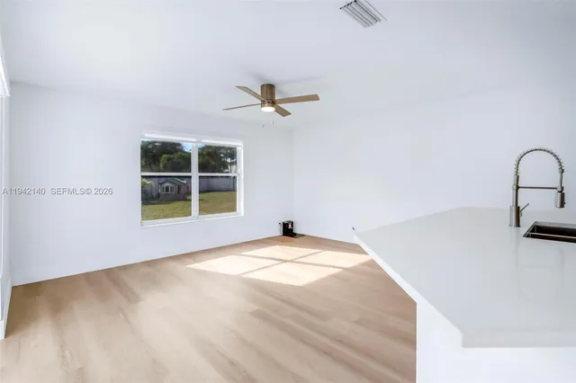 a view of a bedroom with a ceiling fan and a window
