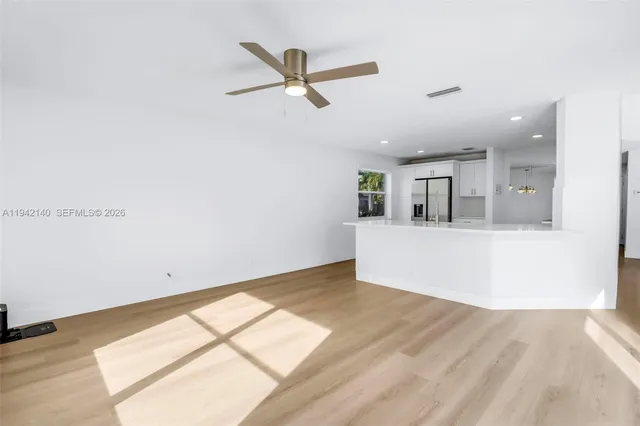 a view of a kitchen with wooden floor and a ceiling fan