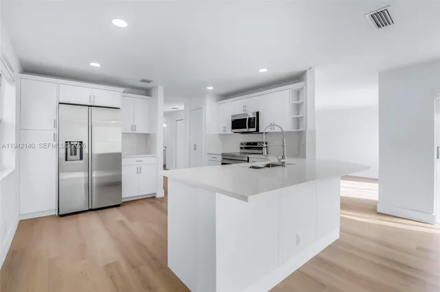 a kitchen with stainless steel appliances a refrigerator stove microwave and sink