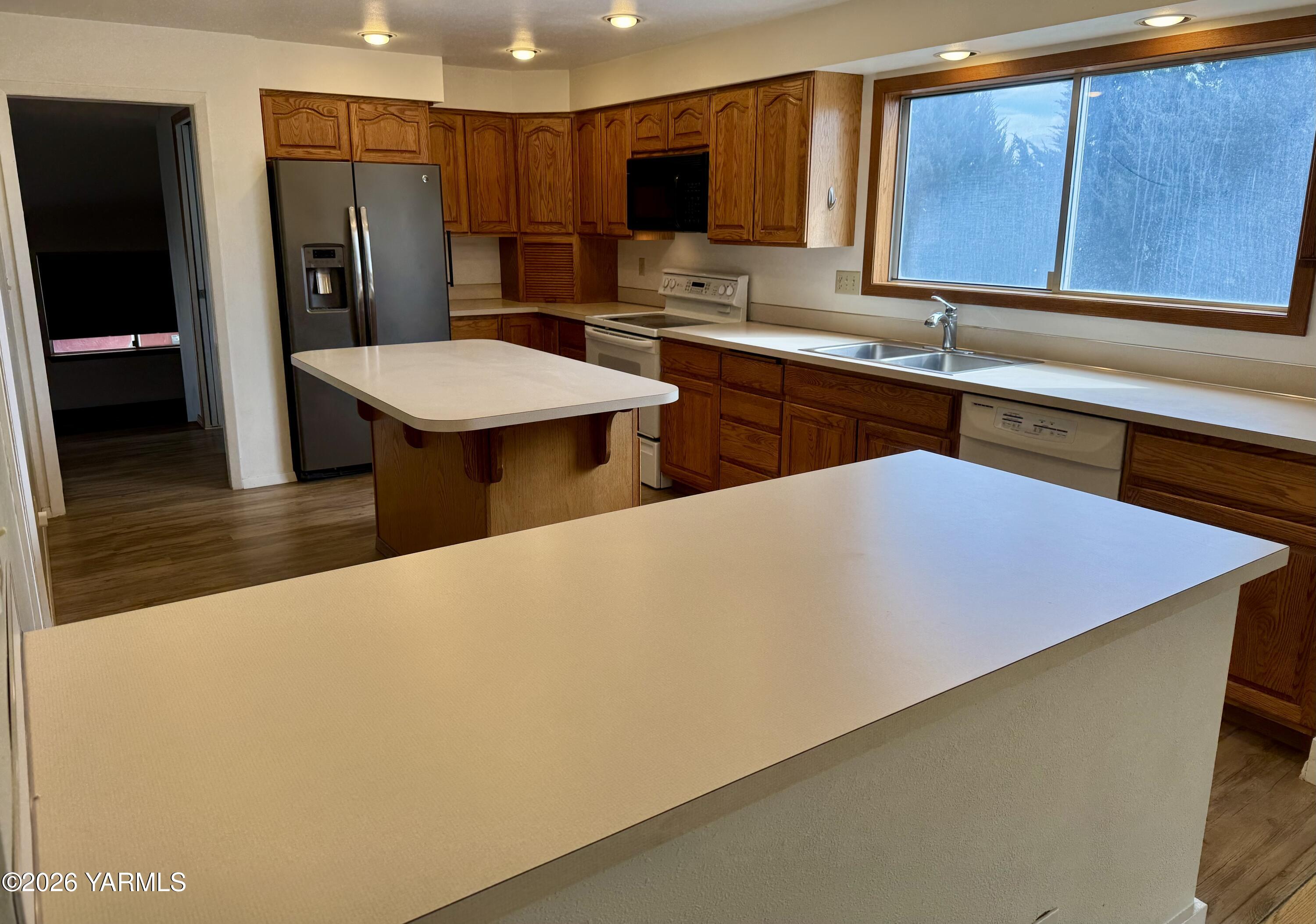 7801 Campbell Road, Unit 1 Toppenish, WA 98948 - Photo 5 of 46 a kitchen with stainless steel appliances a sink cabinets and wooden floor