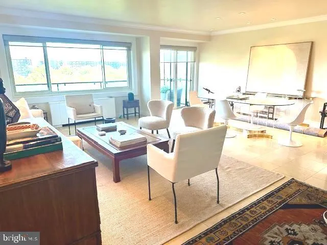 a living room with couches a coffee table and next to a window