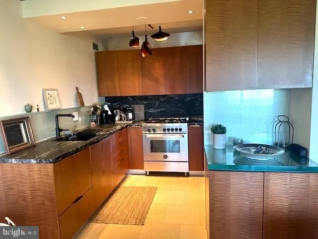 a kitchen with stainless steel appliances granite countertop a sink stove and refrigerator