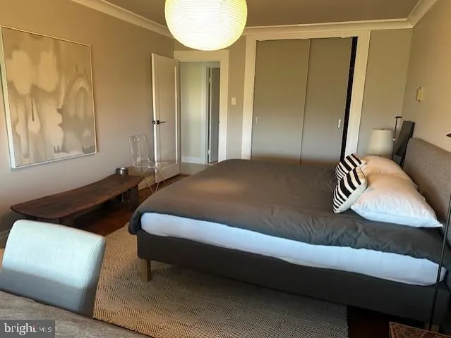 a bed sitting in a bedroom next to a window and a chandelier