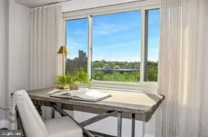 a view of a city from a dining room with a table and chairs