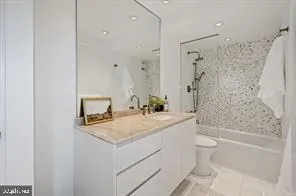 a bathroom with a granite countertop sink a toilet and shower