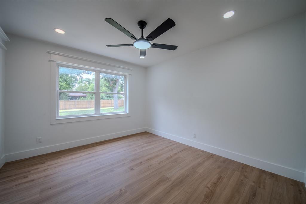 920 Treasure Road Garland, TX 75041 - Photo 10 of 19 an empty room with wooden floor fan and windows