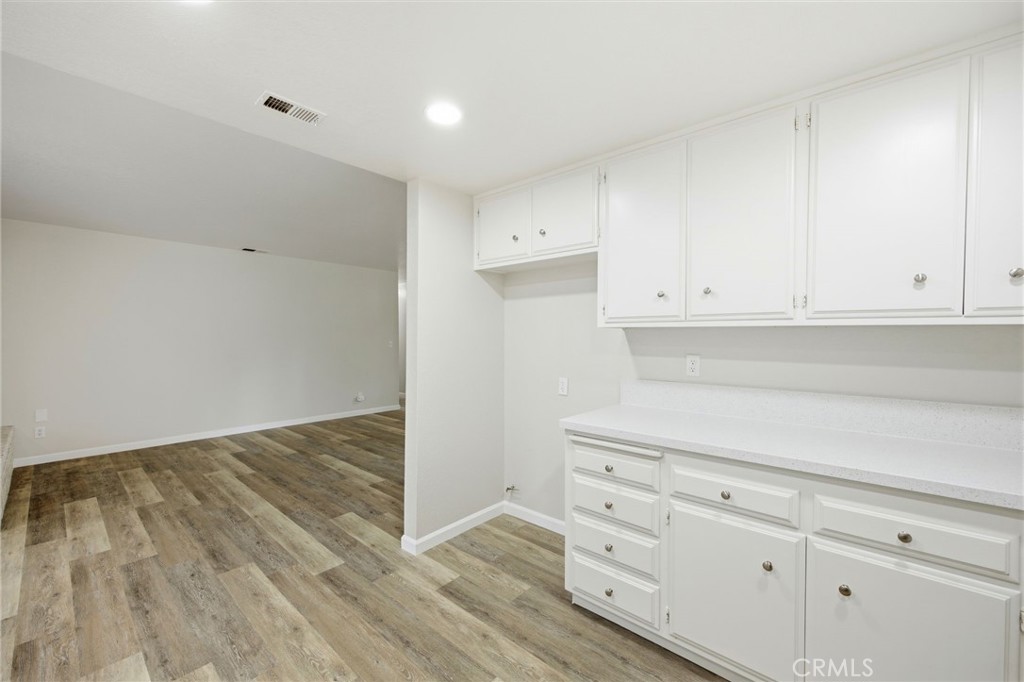 13240 Olive Tree Lane Poway, CA 92064 - Photo 19 of 50 a kitchen with white cabinets and a wooden floor