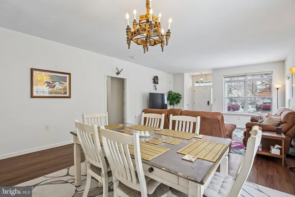 a kitchen with stainless steel appliances a refrigerator a stove top oven a sink dishwasher and white cabinets with wooden floor