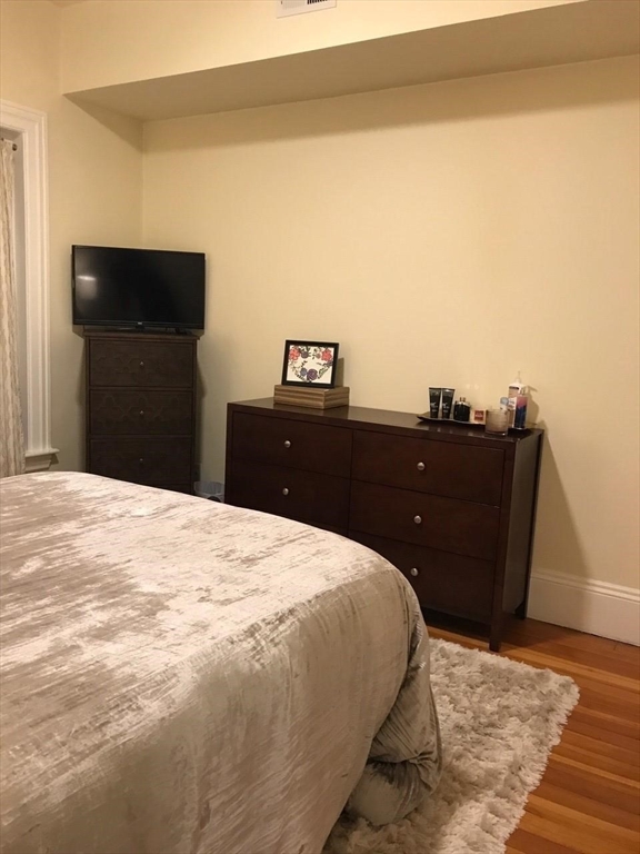 1463 Beacon Street, Unit 32 Brookline, MA 02446 - Photo 4 of 10 a bedroom with a bed and dresser