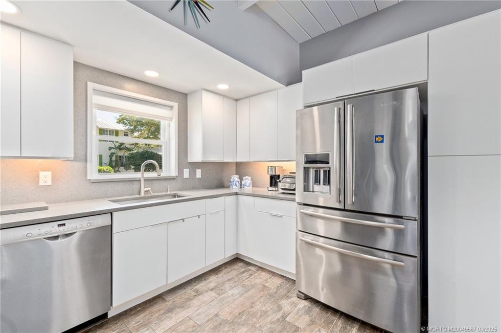 530 South Manor Drive Stuart, FL 34994 - Photo 19 of 55 a kitchen with white cabinets and stainless steel appliances