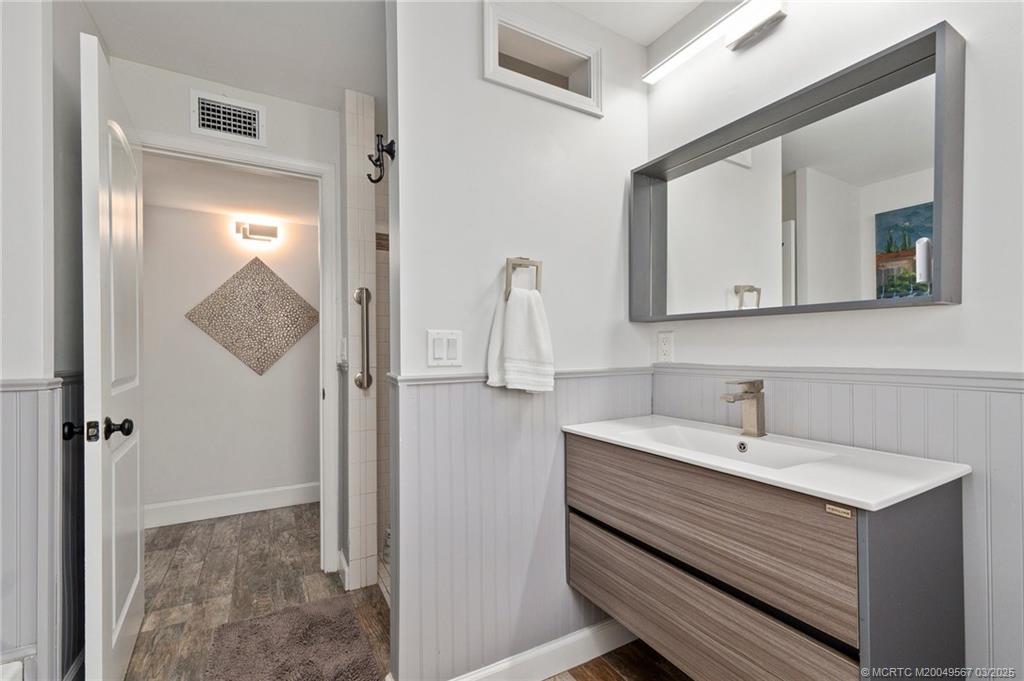 530 South Manor Drive Stuart, FL 34994 - Photo 27 of 55 a bathroom with a sink a mirror and shower
