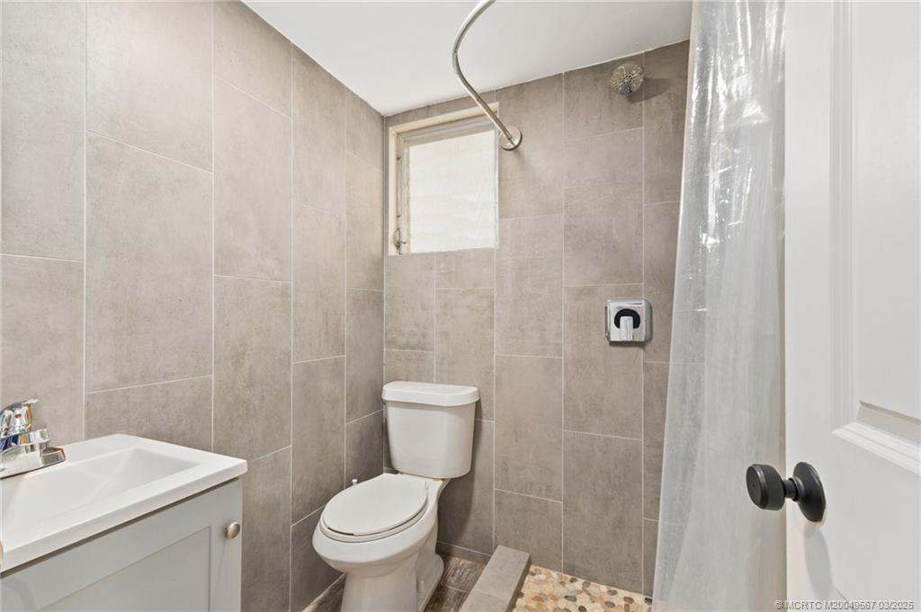 530 South Manor Drive Stuart, FL 34994 - Photo 41 of 55 a bathroom with a toilet a sink and shower