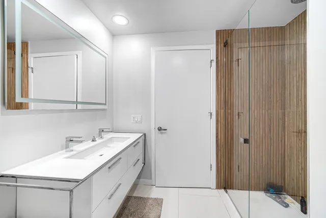 a bathroom with a sink a mirror and a shower