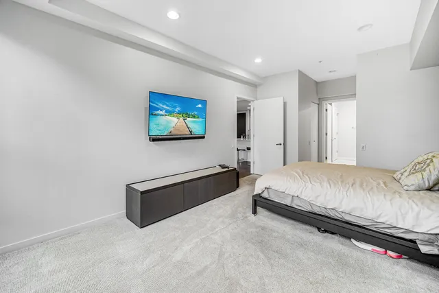 a spacious bedroom with a bed and a flat screen tv