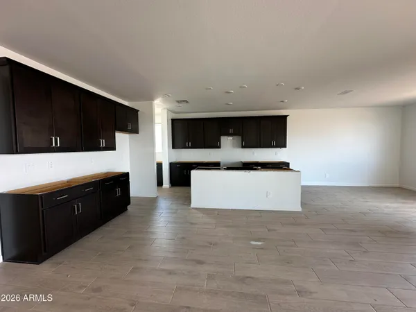 a large kitchen with stainless steel appliances a large counter top a stove a microwave a sink and cabinets