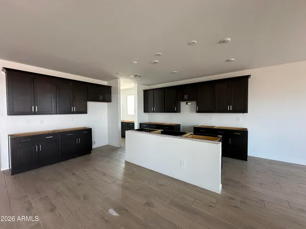a living room with stainless steel appliances kitchen island granite countertop a wooden floors a stove and a microwave