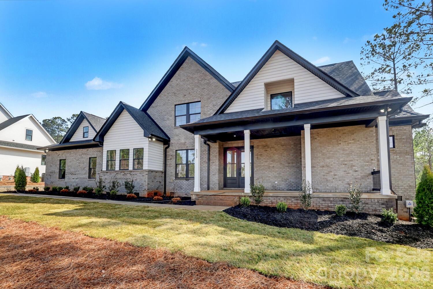 a front view of a house with a yard outdoor seating and garage