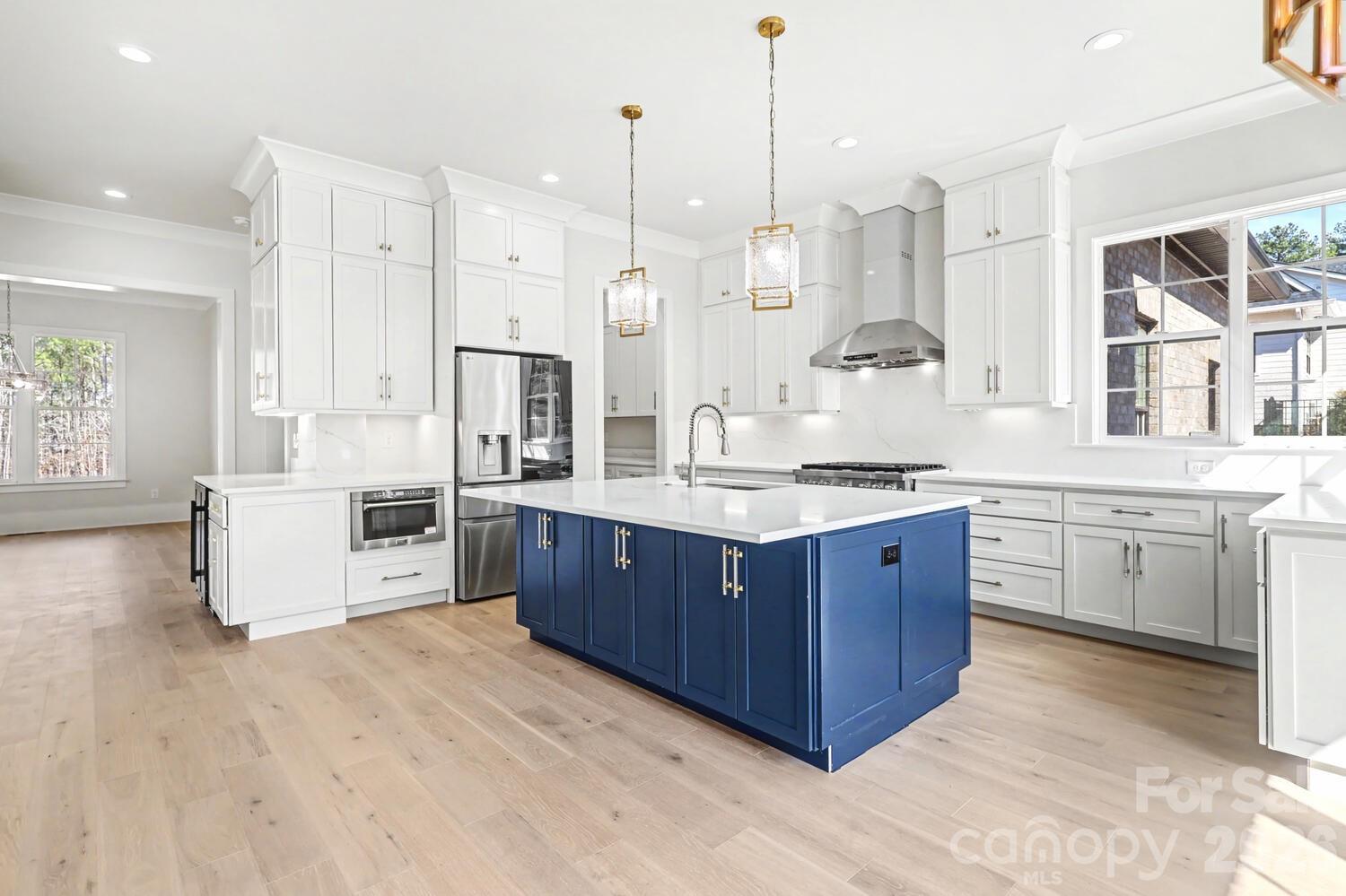 3210 Sherman Drive Lancaster, SC 29720 - Photo 13 of 44 a large kitchen with stainless steel appliances kitchen island granite countertop a stove a sink and white cabinets with wooden floor