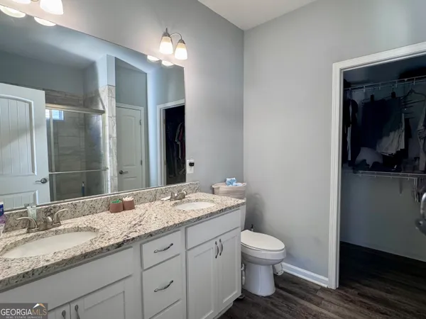 a bathroom with a granite countertop sink a toilet and a mirror