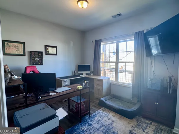 a view of a workspace with furniture and a window
