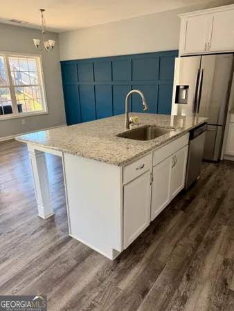 a kitchen with stainless steel appliances granite countertop a sink a microwave a refrigerator and a stove