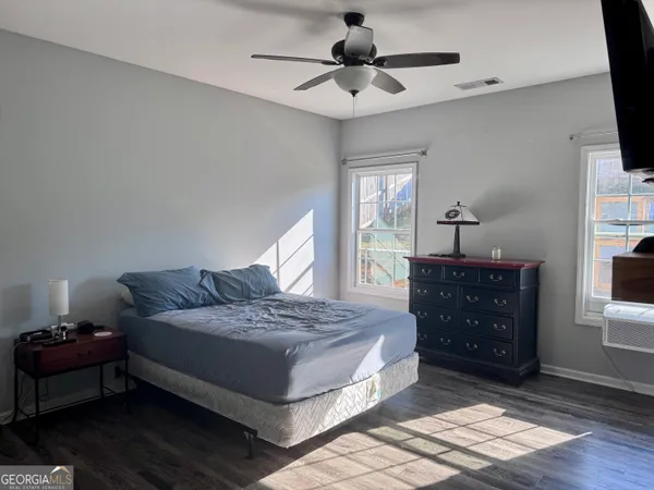 a bedroom with a bed and a flat tv screen on dresser