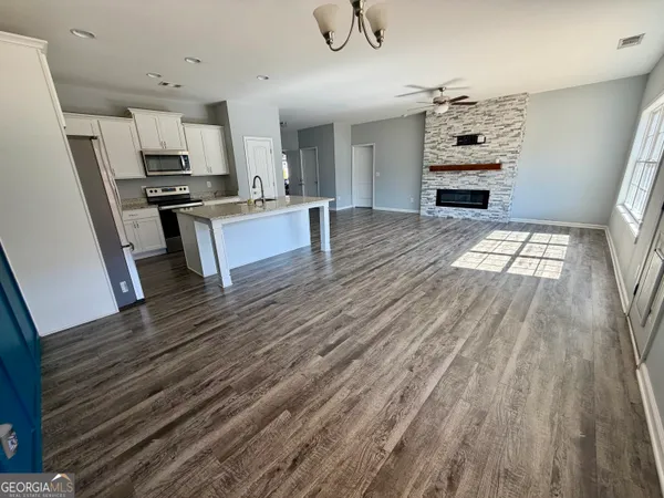 a large kitchen with cabinets wooden floor and stainless steel appliances