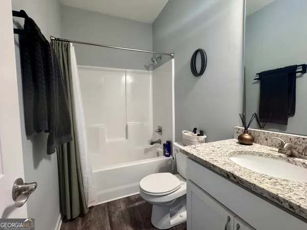 a bathroom with a granite countertop sink toilet and shower