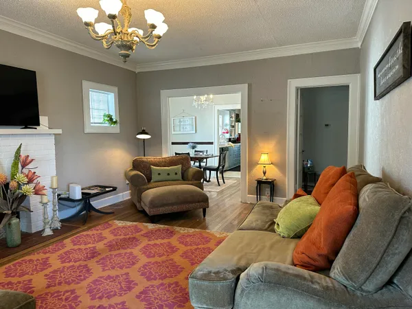 a living room with furniture a chandelier and a flat screen tv