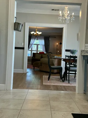 a living room with furniture and a chandelier