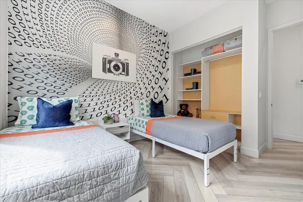 a bedroom with a bed and a chair with the wooden floor