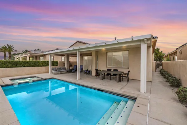 a view of swimming pool with outdoor seating and a garden