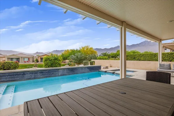 a view of roof deck with wooden floor and fence next to a yard