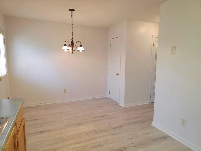 a view of a room with wooden floor and chandelier