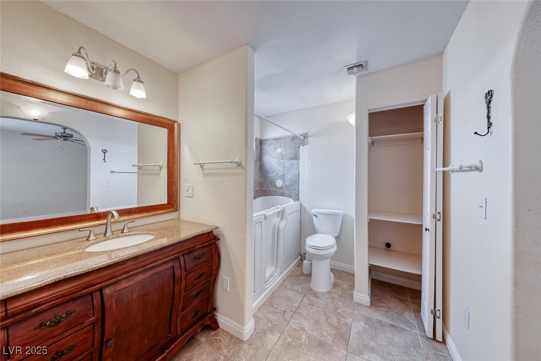 632 Arrayo Way Boulder City, NV 89005 - Photo 28 of 40 Bathroom with a ceiling fan, a shower, vanity, toilet, and a bathtub