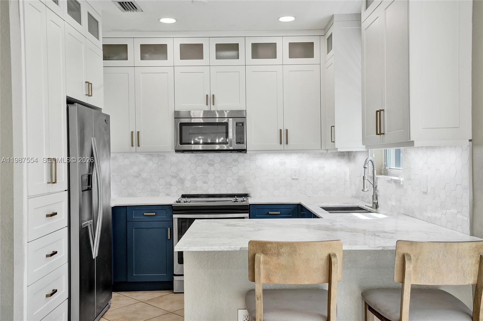 12554 Southwest 125th Terrace Miami, FL 33186 - Photo 12 of 41 a kitchen with stainless steel appliances a stove refrigerator sink and cabinets
