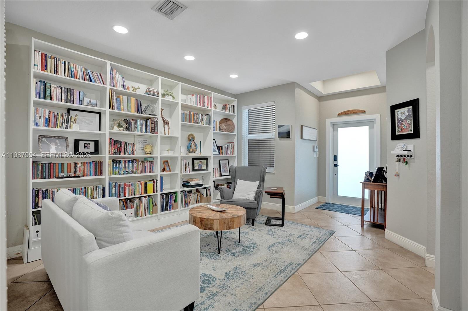 12554 Southwest 125th Terrace Miami, FL 33186 - Photo 4 of 41 a living room with furniture and a book shelf